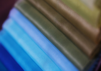 colorfull textile lies on a colorfull palette of the artist.Colored brushes and fabrics.