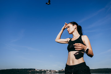 Young sports fitness woman make stretching exercises at the beach outdoors listening music with earphones.