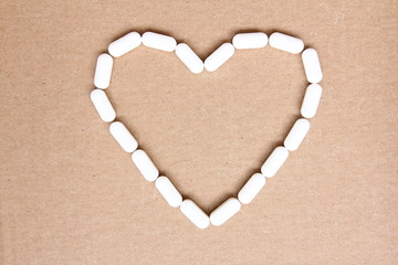 Naklejka na ściany i meble Heart - symbol made of white tablets on cardboard - medicines