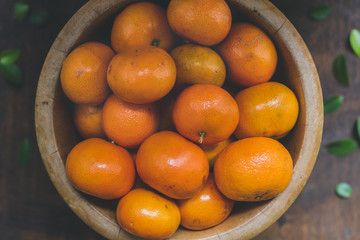 Fresh orange bowl on the rustic wood table.