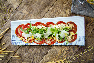Carpaccio meat with parmesan cheese and arugula