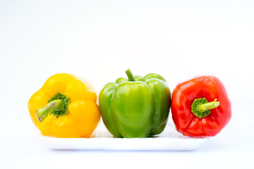 colorful vegetable, yellow, green and red, bell pepper on foam tray isolated on white background
