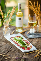 Carpaccio meat with parmesan cheese and arugula