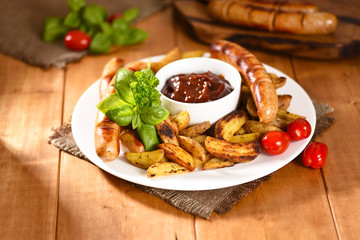 Fried fries with sausages and ketchup. Full, delicious food and not healthy.