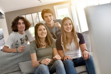 Group of friends cheering up as watching game on TV