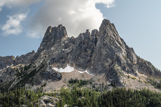 The Washington Section of the Pacific Crest Trail in the North Cascades with view of cloud covered rocky mountains and snow.