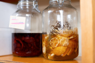 Ring-cut lemons and rosemary in a large glass jar