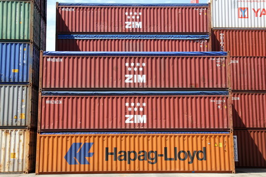 HAMBURG, GERMANY - JUNE 30, 2019: Stacked open top shipping containers of ZIM Integrated Shipping Services Ltd. and HAPAG-LLOYD at the Port of Hamburg