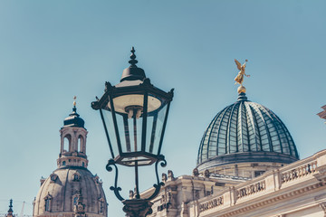 Historische Gaslaterne in Dresden - im Hintergrund die Frauenkirche und die Glaskuppel der Kunstakademie - obrazy, fototapety, plakaty