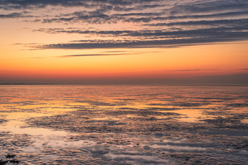 Abenddämmerung mit Spiegelungen am norddeutschen Wattenmeer.