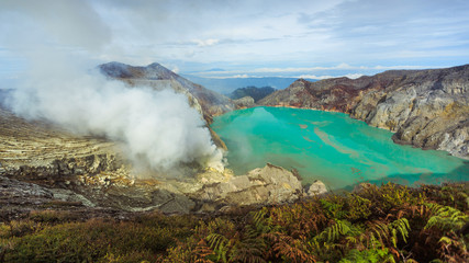 Active Ijen Volcano in West Java. Blue lake with sulfuric acid. Sulfur mining. Poisonous smoke and blue lights. Toxicity. 