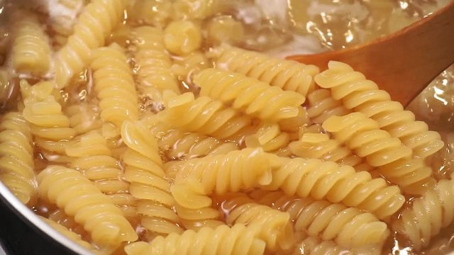 hot fusilli pasta with rising steam close-up. Food preparation