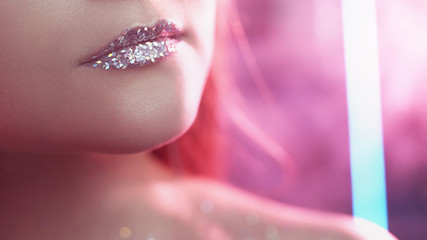 Fashion makeup art. Aesthetic cosmetology. Woman with glitter lips in pink neon light smoke.