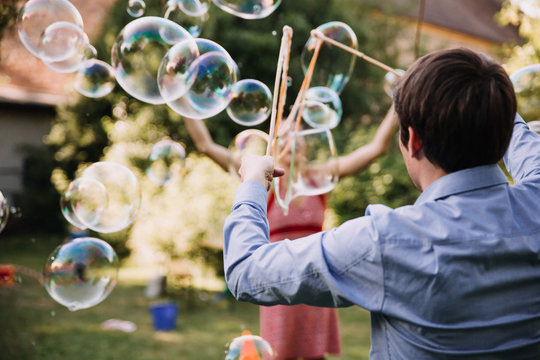 a couple playing with bubbles outdoor together
