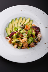 Avocado and shrimp salad in a white bowl plate