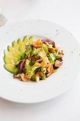Avocado and shrimp salad in a white bowl plate