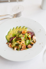 Avocado and shrimp salad in a white bowl plate