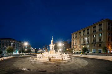 Naples, Italy. Fountain Of Neptune On Piazza Municipio In Evening Or Night Illuminations
