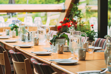 Cozy Interior Of Summer Cafe. Jug Of Water On Table And Cutlery Laid Out