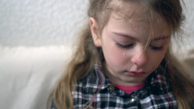 Crying little girl portrait. Close up of crying child aged four. Tears close up.