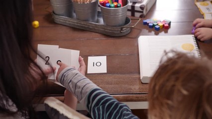 Mother Teaching Basic Counting To Her Little Son. Behind the shoulder video as kid learning counting with his mom. - Powered by Adobe