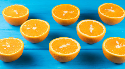 cut oranges on a blue wooden background