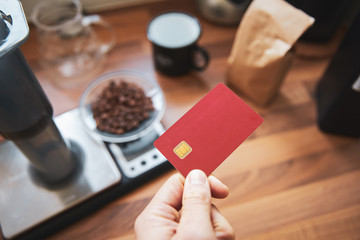 Man holding blank debit card in a coffee shop