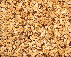 Full frame of a roasted pile of sliced almonds, texture, ingredients, background.