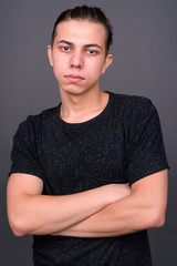 Obraz premium Young handsome man with hair tied looking confident