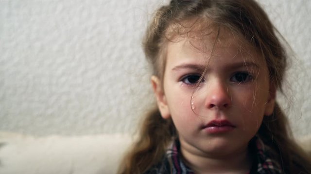 Upset child. Little girl grumpy. Child abuse concept. Tears on the face. Orphanage life and bullying.