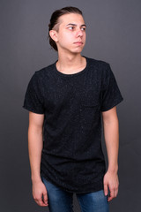 Obraz premium Young handsome man with hair tied thinking and looking away