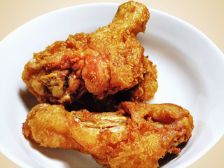 Crispy Fried Chickens on White Dish Isolated on Light Brown Background