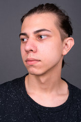 Obraz premium Face of young handsome man with hair tied looking away