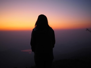 silhouette of a woman standing on a rock