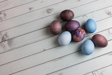 Colored Easter eggs on a light wooden table. Chicken eggs are painted for the Easter holiday.