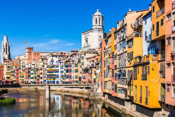 Fototapeta na wymiar Colorful houses, Onyar river and Saint Mary Cathedral at background in Girona, Spain