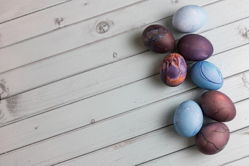 Colored Easter eggs on a light wooden table. Chicken eggs are painted for the Easter holiday.