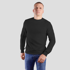 Fototapeta premium Template of black blank pullover on a man in blue jeans, fashionable heather for design presentation.