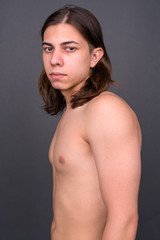 Young handsome androgynous man with long hair shirtless