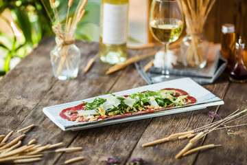 Carpaccio meat with parmesan cheese and arugula