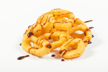 fried squid rings in batter with tyriaki sauce, on an isolated white background