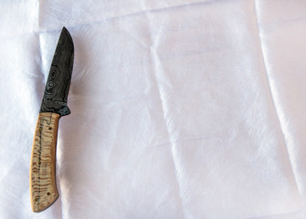 This one is a beauty from the tip of the damascus blade to the butt of the wooden handle. The avid knife collector or hunter would love this useable piece of art. Bokeh. © Picunique