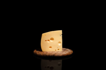 fresh cheese is lying in a Board on a black background