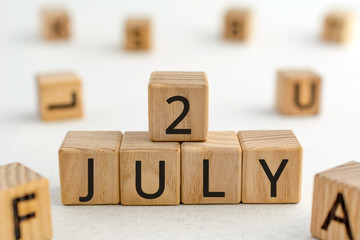 July 2 - from wooden blocks with letters, important date concept, white background random letters around