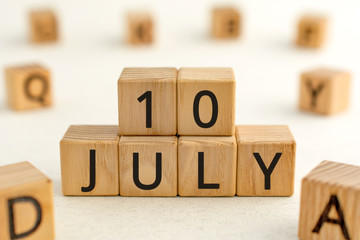 July 10 - from wooden blocks with letters, important date concept, white background random letters around