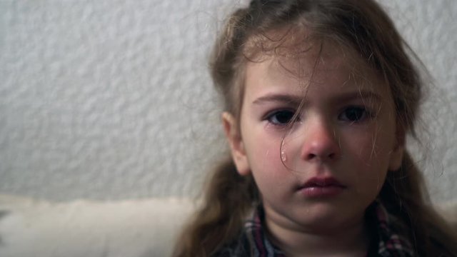 Crying little girl. Tears on the face of child aged four.