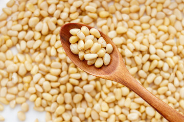 Close up of Pine nuts in a wooden spoon. Peeled pine nuts