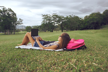   Young woman using laptop computer on a park. Freelance work concept     