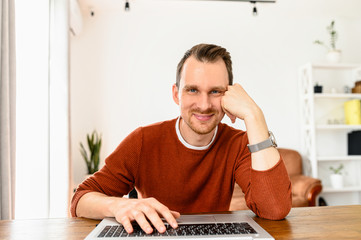 Online conversation with friend. Webcam view of attractive young man, he is smiling and looks at...