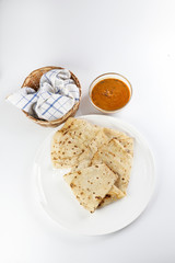 Paper thin rumali roit wheat chapati bread on white plate best served with dal tadka makhana